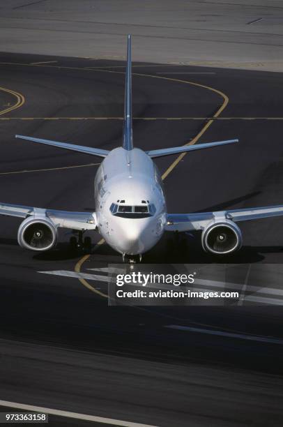 International Boeing 737-300 taxiing from the taxiway onto the active runway.