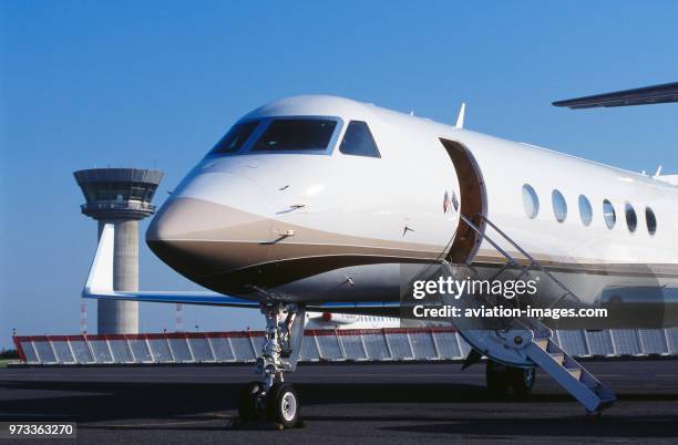 Gulfstream 500 parked with blast fence and air-traffic control-tower behind nose-wheel undercarriage, airstairs and winglet of golfer Greg Norman's...