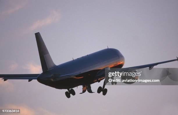 Generic Airbus A320-200 climbing out after take-off with undercarriage retracting at dusk.