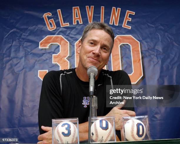 New York Mets' pitcher Tom Glavine is all smiles as he sits behind a row of baseballs, with numbers denoting his achievement, at a news conference...