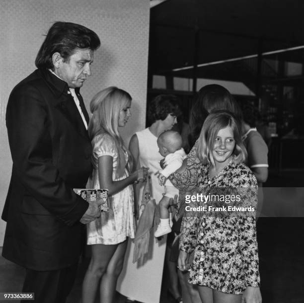 American singer-songwriter Johnny Cash arrives in Hollywood with his stepdaughters, Carlene Carter and Rosie Nix Adams , July 1970. Behind Rosie, her...