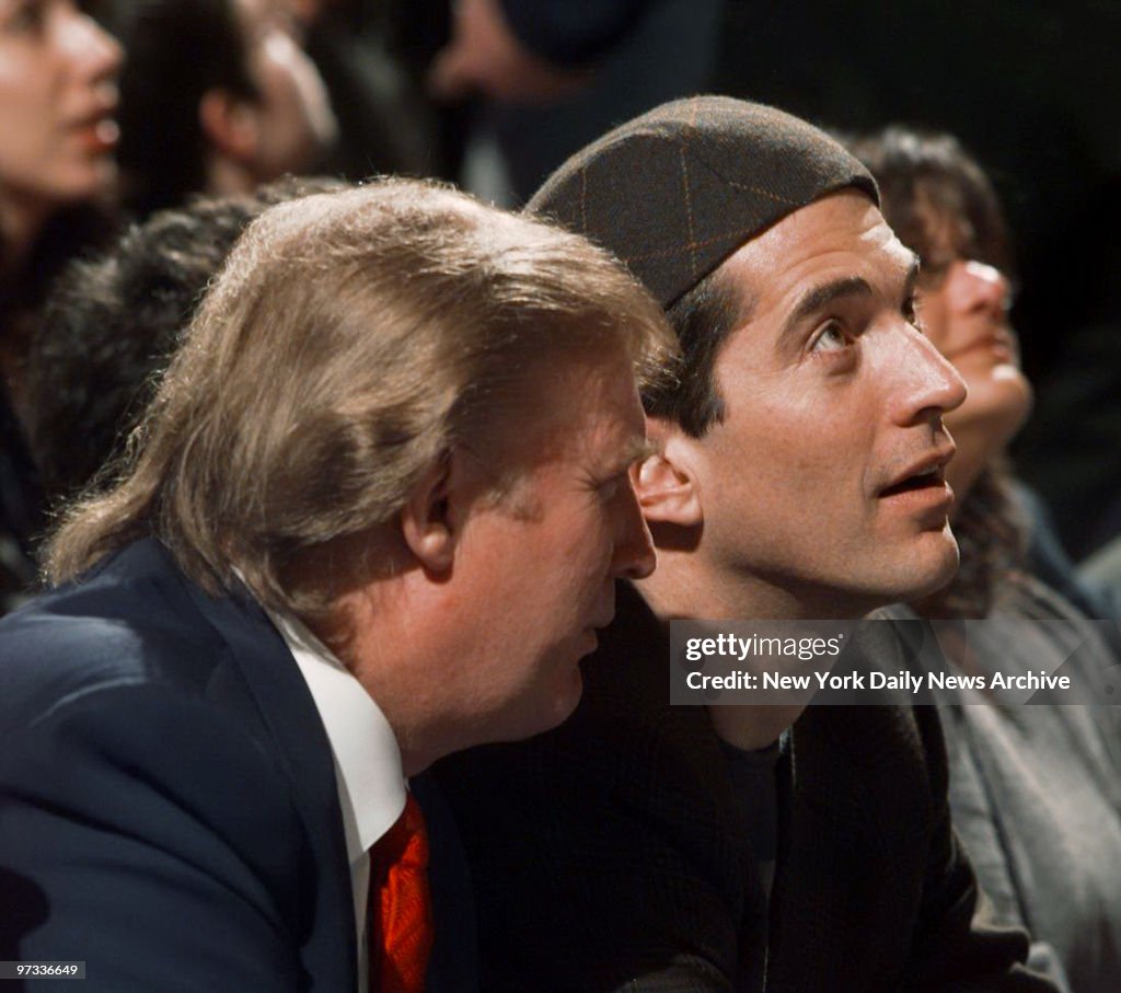 Donald Trump (left) and John F. Kennedy Jr. take in the acti