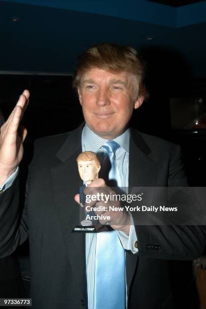 Donald Trump holds his own bobble head doll while attending a viewing party at Planet Hollywood for episode four of his reality show "The Apprentice."