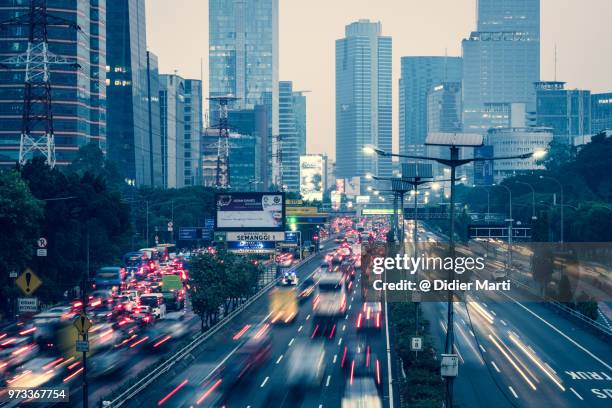 heavy traffic captured with blurred motion along the gatot subroto highway in the heart of jakarta business district in indonesia - emerging markets stockfoto's en -beelden