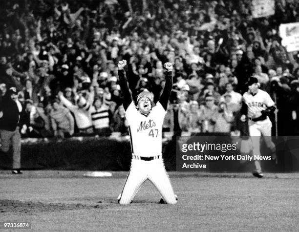 New York Mets' reliever Jesse Orosco and thousands of Met fans lift arms in jubilation as Marty Barrett, last Boston Red Sox hitter, bites dust at...