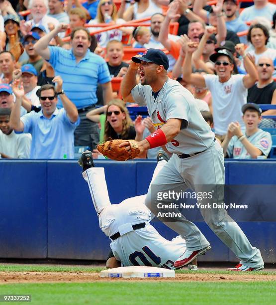 New York Mets right fielder Endy Chavez tumbles after sliding safely into first base in the third inning as St. Louis Cardinals first baseman Albert...