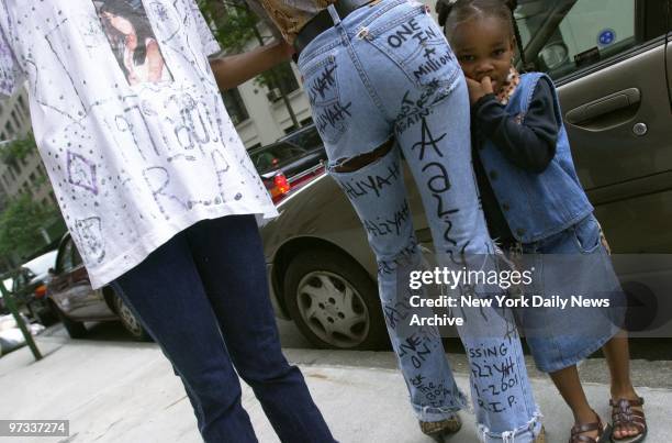 Pamela Deckard and Shanti Gunn wear their tributes to Aaliyah as Gunn's daughter, Amani Davis looks on outside St. Ignatius Loyola Roman Catholic...