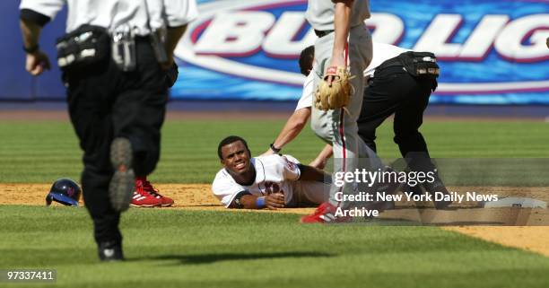 New York Mets' rookie Jose Reyes grimaces in pain after spraining his ankle trying to break up a game-ending double play with a slide into second in...