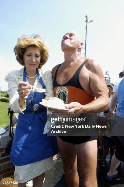 Parks Commissioner Bernadette Castro serves a slice of birthday cake to Reggie Jones at a celebration of the 75th anniversary of Jones Beach State...