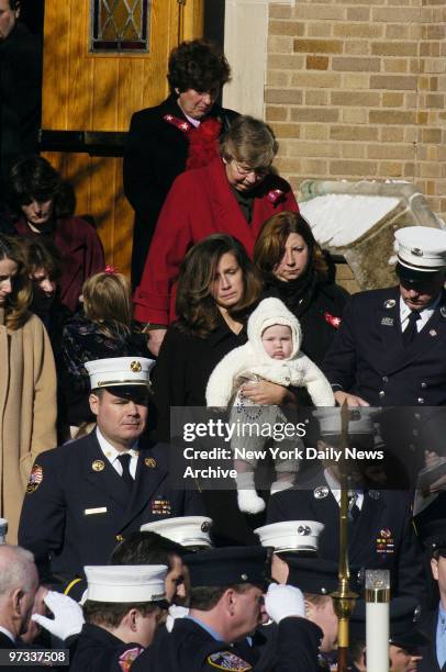 Widow Eileen Bellew holds her 5-month-old son, Kieran John, as she leaves St. Margaret's Church in Pearl River, N.Y., after funeral services for her...