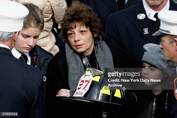 Widow Jeanette Meyran is accompanied by her son, Dennis and daughter Angela as firefighter gives her the helmet belonging to her husband, FDNY Lt....