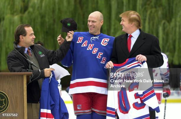 Parks Commissioner Adrian Benepe presents New York Rangers' captain Mark Messier with a cap as Donald Trump holds a Rangers jersey bearing his name...