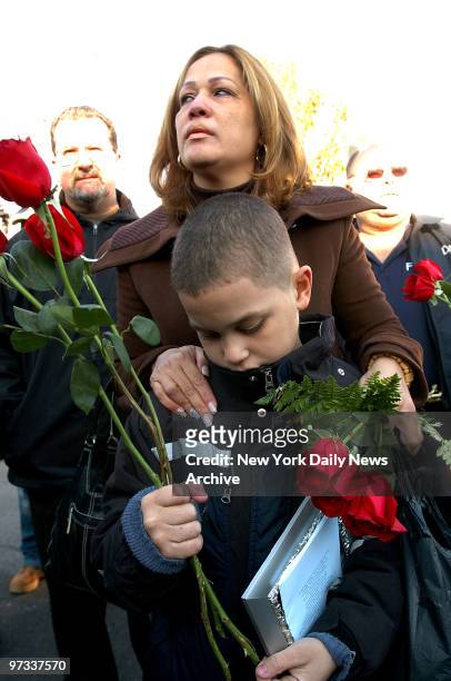 Widow Olivia Sanchez, who lost her husband, Elvis Sanchez, comforts her son, 9-year-old Elvis Sanchez Jr., during a memorial service this morning on...