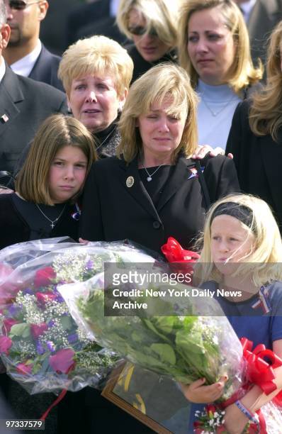 Widow Suzanne Oelschlager and her two children, Brittany , and Kayla carry flowers after memorial service for Firefighter Douglas Oelschlager of...