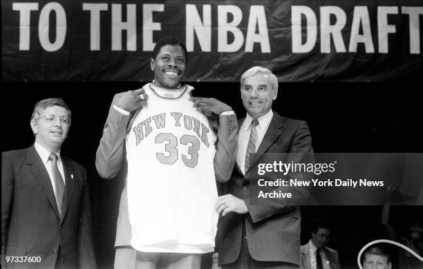 Patrick Ewing towers over Knicks VP Dave DeBusschere as he tries on New York Knicks jersey for size.