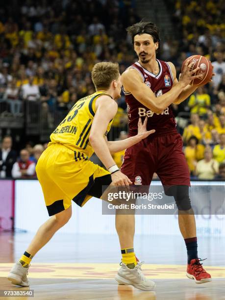 Nihad Djedovic of Bayern Muenchen competes with Luke Sikma of ALBA Berlin during the fourth play-off game of the German Basketball Bundesliga finals...