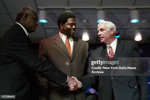 Willis Reed shakes hands with Dave DeBusschere as Patrick Ewing looks on during a news conference at the Theater in Madison Square Garden before...