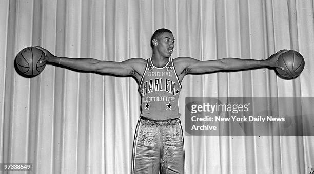American basketball player Wilt Chamberlain, formerly with the University of Kansas, hold a basketball in each hand, at Toots Shor's, New York, New...