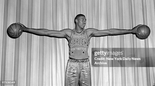 American basketball player Wilt Chamberlain, formerly with the University of Kansas, hold a basketball in each hand, at Toots Shor's, New York, New...