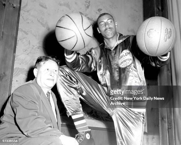 Wilt Chamberlain, formerly with the University of Kansas, with Abe Saperstein at Toots Shor's. Chamberlain signed with the Harlem Globetrotters for a...