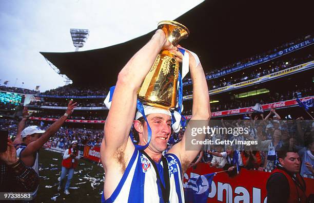 Corey McKernan celebrates with the preimership trophy after the AFL Grand Final match between the North Melbourne Kangaroos and the Sydney Swans at...