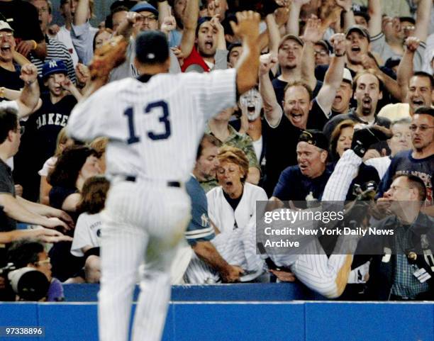 With Alex Rodriguez backing him up, Derek Jeter dives into Stadium stands to make run-saving catch by Boston's Trot Nixon in 12th during game against...