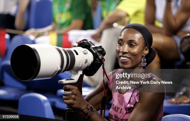 Star Lisa Leslie, who's on the U.S. Olympic women's basketball team, borrows a photographer's camera to snap some shots of the men's basketball team...