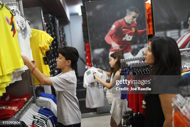 Matthias Meyer, Mia Meyer and their mother Vanessa Meyer shop at the Soccer Locker store for German soccer team items as they prepare to show their...