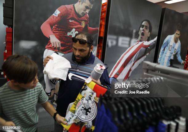 David Prego and his father Rodrigo Prego shop at the Soccer Locker store for German soccer team items as they prepare to show their support for their...
