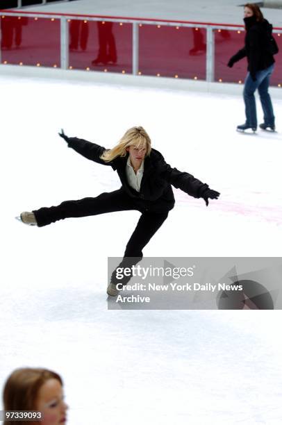 Woman twirls gracefully on the Rockefeller Center ice skating rink on a late fall afternoon.