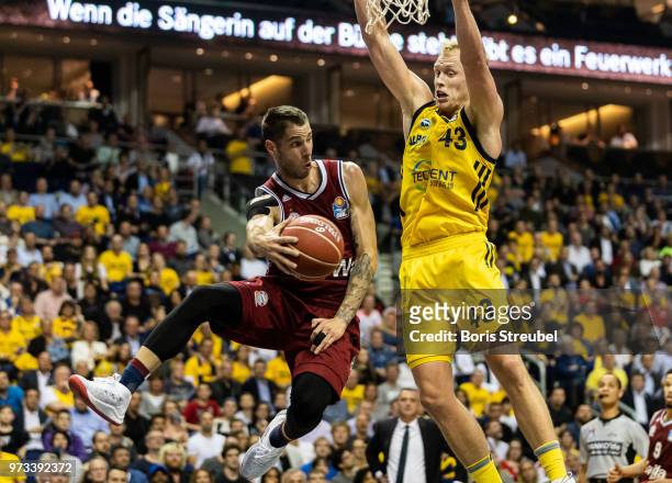 Stefan Jovic of Bayern Muenchen competes with Luke Sikma of ALBA Berlin during the fourth play-off game of the German Basketball Bundesliga finals at...
