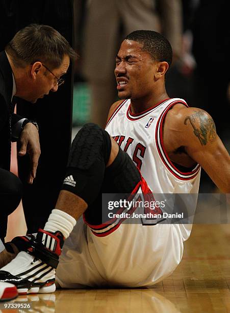 Trainer Fred Tedeschi of the Chicago Bulls attends to Derrick Rose following a collision in the first quarter against the Atlanta Hawks at the United...