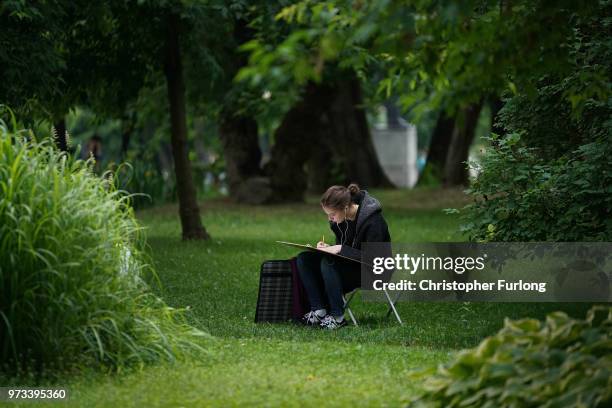 On the eve of the World Cup a woman sketches in Gorky Park on June 13, 2018 in Moscow, Russia. On the eve of the first game of the World Cup it was...