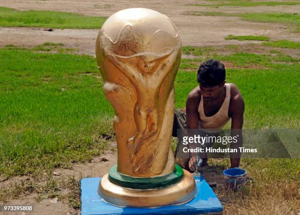 Idol makers carry idols of some of the icon footballers like Messi, Neimar and Ronaldo and a replica of World Cup to a fan club at Baghajatin, on...