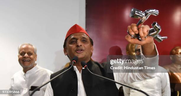 Samajwadi Party Chief Akhilesh Yadav holds water taps while addressing a press conference at party head office on the bungalow issue on June 13, 2018...