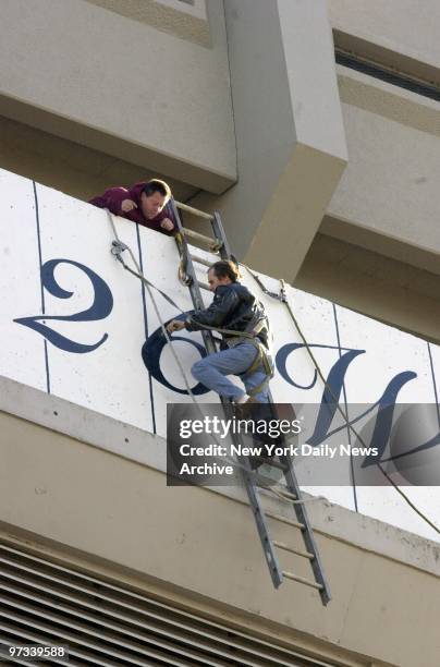 Workers at Yankee Stadium paint a "six" over the number "five" that had signified the number of World Series wins the New York Yankees had prior to...