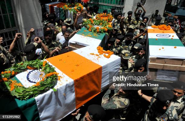 Border Security Force personnel carry the coffins of four BSF personnel, killed in cross border firing, after a wreath laying ceremony at Paloura BSF...