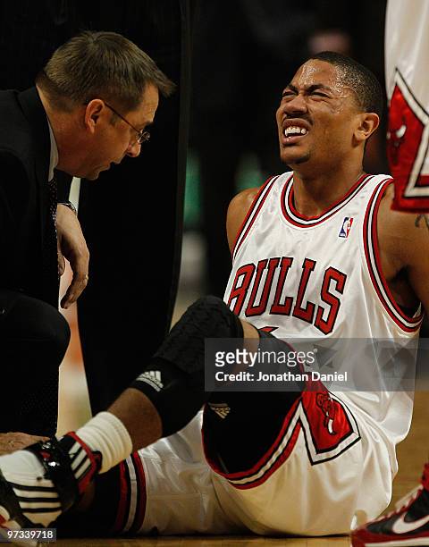 Trainer Fred Tedeschi of the Chicago Bulls attends to Derrick Rose following a collision in the first quarter against the Atlanta Hawks at the United...