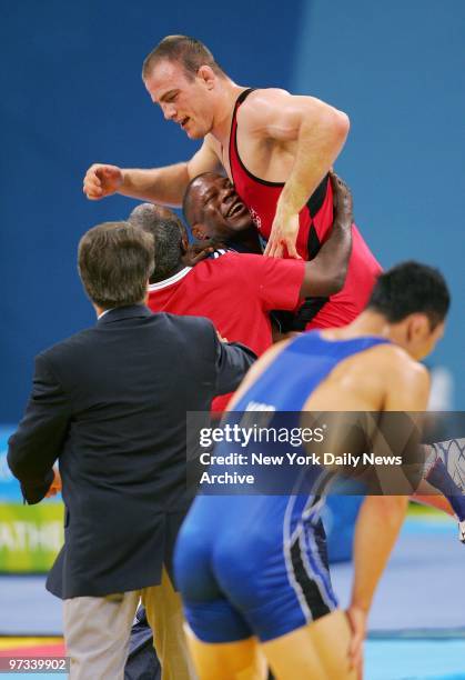 Wrestler Cael Sanderson of the U.S. Is hoisted by his coaches after defeating Eui Jae Moon of Korea to win the men's freestyle 84kg gold medal match...