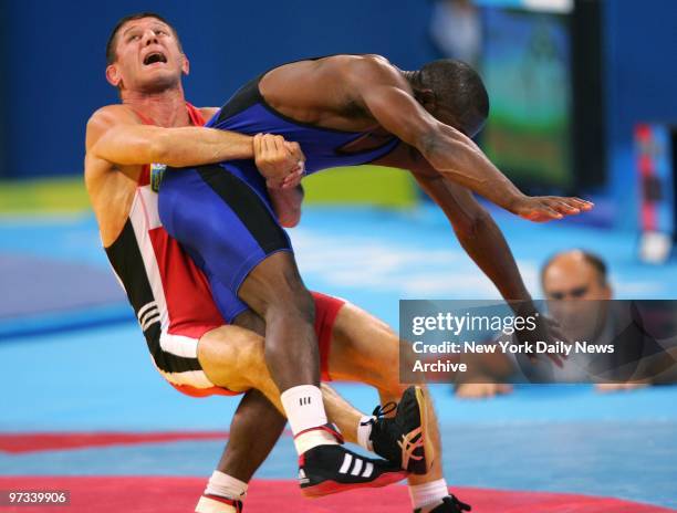 Wrestler Elbrus Tedeyev of the Ukraine takes down Jamill Kelly of the U.S. During the men's freestyle 66kg final match in the Ano Liossia Olympic...