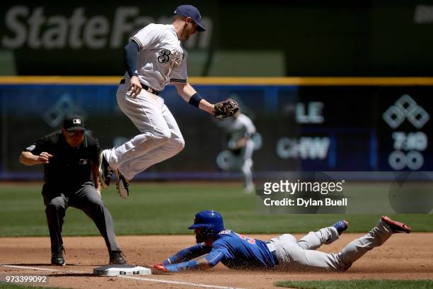 Javier Baez of the Chicago Cubs steals third base past Travis Shaw of the Milwaukee Brewers in the second inning at Miller Park on May 27, 2018 in...