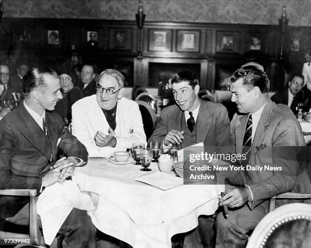 Yankee shortshop Frank Crosetti, San Francisco Chronicle Sports Editor Harry B. Smith, Joe DiMaggio, and ex-champ Jack Dempsey sit around the table...