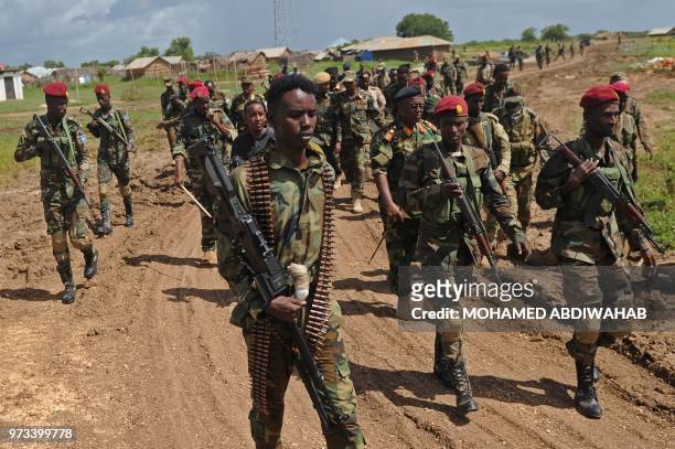 Somali soldiers walk at Sanguuni military base, where an American special operations soldier was killed by a mortar attack on June 8, about 450 km...