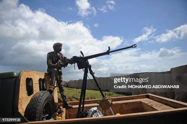 Somali soldier holds a machine gun at Sanguuni military base, where an American special operations soldier was killed by a mortar attack on June 8,...