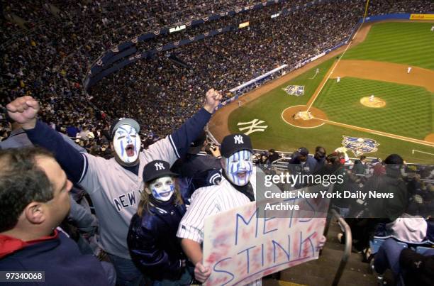 Yankee fans Jeff and Jessica Mindo and Jose Soler , faces painted blue and white, prepare to root for their favorite team before Game 2 of the World...