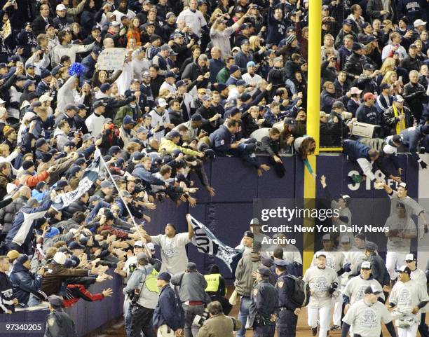 Yankees fans reach out to touch greatness - in the form of the team - in on-field festivities after Bombers secured their first World Series victory...