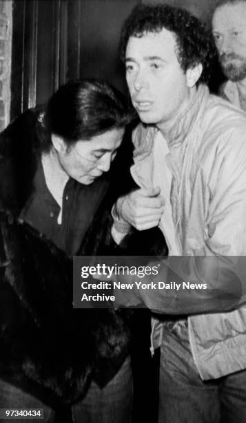 Yoko Ono is helped by David Geffen as she leaves Roosevelt Hospital after learning her husband, John Lennon, had died after being shot by Mark...