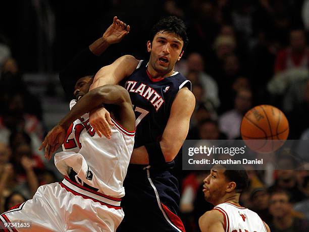 Zaza Pachulia of the Atlanta Hawks gets tangled up with Hakim Warrick of the Chicago Bulls as they battle for a rebound at the United Center on March...