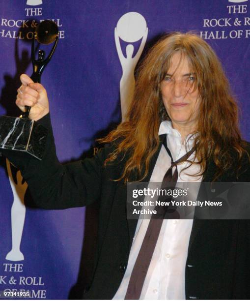 Patti Smith clutches her statuette as she takes the stage in the press room at the Waldorf Astoria hotel during the 22nd annual Rock and Roll Hall of...