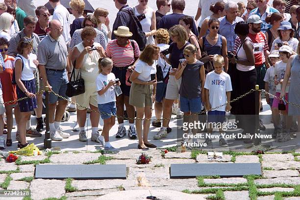 People pay their respects at the gravesite of John F. Kennedy in Arlington National Cemetery, after John F. Kennedy Jr.'s plane disappeared off the...
